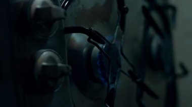 Kirli mutfak sobasında dökülen kahve lekeleriyle yanan mavi gaz..