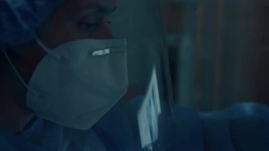 Laboratuvar kıyafeti giyen kadın mühendis GPU grafik kartı tutuyor..