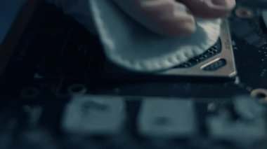 Teknisyenler GPU grafik kartının üzerindeki kiri elle temizliyorlar..