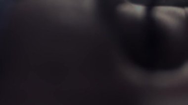 İşi bitirdikten sonra kameraya bakan bir doktorun yorgun gözleri. Doktorun koruyucu maskeyi çıkardığı ve nefes aldığı yakın plan..