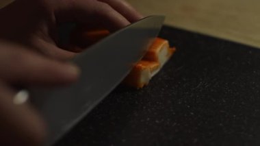 Kesme tahtasındaki yengeç çubuklarını kesmek.