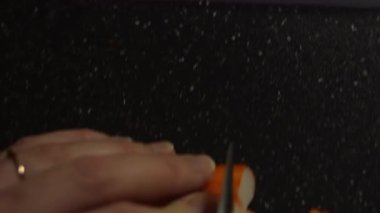 Siyah kesme tahtasındaki yengeç çubuklarını kesiyorum..