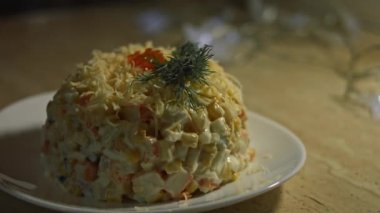 Yengeç salatası tabakta servis edilir ve rendelenmiş peynir ve kırmızı havyarla süslenir..