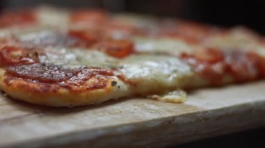 Sıcak kalp şeklinde pizza, salam ve mozzarella ile ahşap tahta üzerinde, makro manzara..