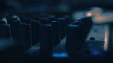 Ses karıştırma konsolunu ayarlayan parmakları kapat. Kayıt stüdyosunda ses üretimi için karıştırıcı konsolu.