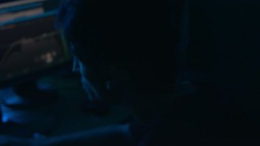 Kayıt stüdyosunda ses düzenleme işlemi. Stüdyoda ışık zayıf.