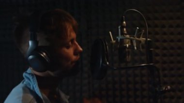 Profesyonel mikrofonlu yakışıklı rap şarkıcısı. Stüdyoda şarkı söylüyor..