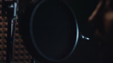 Stüdyo mikrofonlu erkek rap şarkıcısının şarkı söylemesi. .