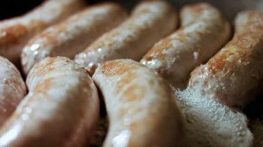 Siyah tavada sosis pişirmenin makro görüntüsü.