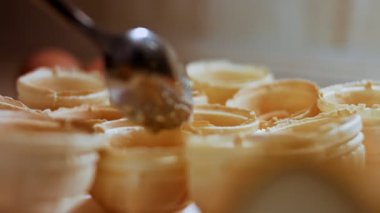 Olivier salatasını kaşıkla tartlara ekliyorum..