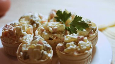 Taze maydanozlu Olivier salatasıyla doldurulmuş tartlarla tabağı süslemek..