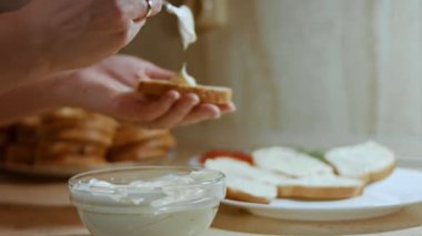 Eller kızarmış ekmeğin üzerine mayonez serpti..