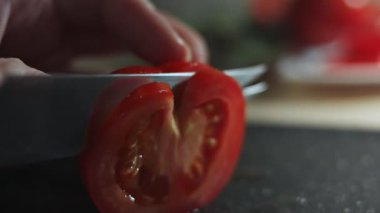 Taze bir domatesi mutfak bıçağıyla dilimlemek, makro manzara..