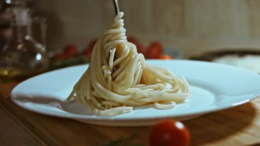 Kaynamış spagettiyi beyaz tabağa koymak..