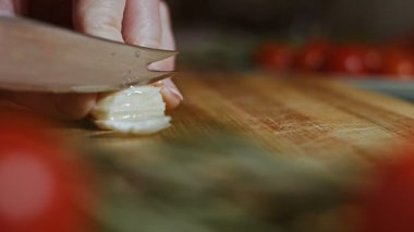 Kadın sarımsak karanfilini küçük parçalara ayırıyor..