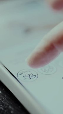 Akıllı telefon ekranında VEGAN simgesi.