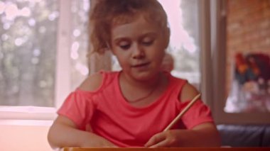 Bir çocuk balkonun camına gökkuşağı çizer. Renkli gökkuşağı resimleri, koronavirüs salgını sırasındaki umudu yayıyor. Covid-19 salgını. Ev kilitlenmesi