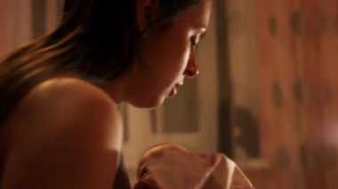 Anne bebeğini küvete koyup yeni doğmuş bir bebeği yıkıyor..