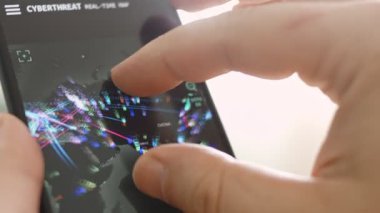 Küresel siber tehdit haritasının görüntüsünü büyüten parmak.