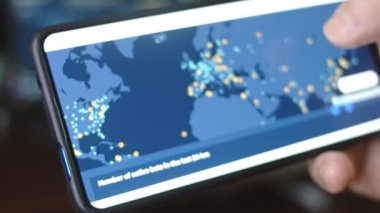 Dünya haritasında gerçek zamanlı siber saldırılar, akıllı telefon ekranında görüntüleme.