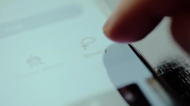 Parmak, akıllı telefon ekranında tespih duasını seçiyor..