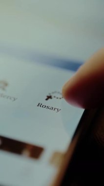 Akıllı telefon uygulamasında tespih çeken Katolik bağlılığı.