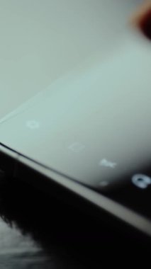 Kamera simgesini akıllı telefon ekranına kaydeden kişi.