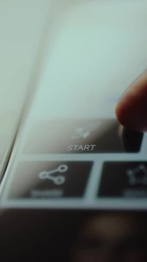 Parmak dijital arayüzdeki Başlat düğmesine tıklamak üzere.