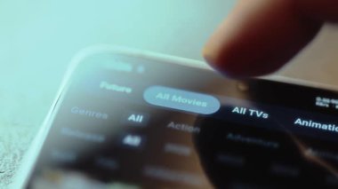 Bir cep telefonunda bir yayın uygulamasının içerik kategorilerinde gezinmek.