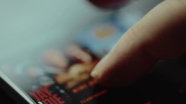 Bir akış uygulamasında Sinema kategorisinin içeriğini kaydıran parmak.