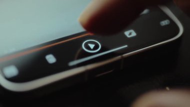Parmak, akıllı telefon ekranındaki bir video için Çal düğmesine tıklıyor.