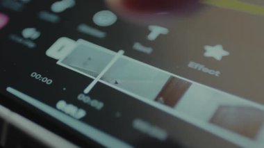 Mobil video düzenleme arayüzü içindeki zaman çizgisi ile etkileşen parmak.
