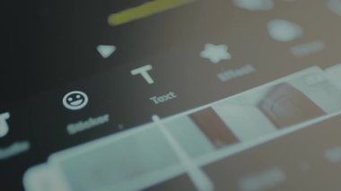 Parmak bir video düzenleme uygulamasında metin seçeneğini seçer.
