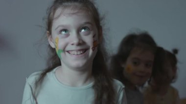 Tarım temasında yüz resimleri olan üç sevimli, neşeli küçük kız. Komik suratlar yapıyorsun. Tarım kavramı.