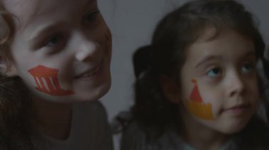 Yüzünde mimari temalı resimlerle gülümseyen üç küçük kız. Mimarlık konsepti.