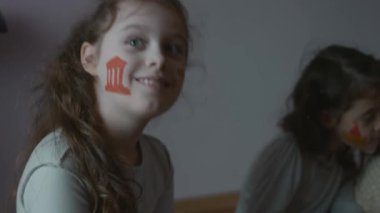 Yüzlerinde mimari temalı tabloları olan üç tatlı küçük kız. Biri neşeyle dans ediyor. Mimarlık konsepti.