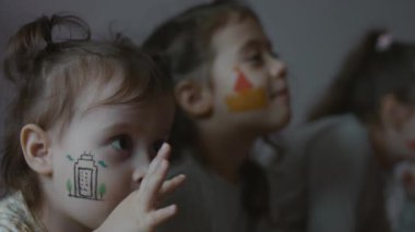 Yüzlerinde mimari teması olan üç sevimli küçük kızdan oluşan bir takım. Mimarlık konsepti.