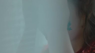 Yüzünde Noel temalı tablolarla neşeli küçük bir kız dikiz oyunu oynuyor..