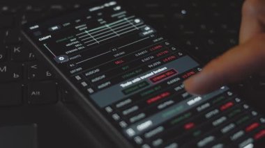 Finansal ticaret platformu için mobil uygulama arayüzü kullanan kişi, çeşitli para birimi çiftleri için verileri gösterir.