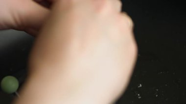 Bir insan bir yumurtayı bıçakla kırar ve onu kalp şeklinde bir yumurta kalıbına döker..