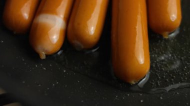 Tavada kızaran sosisler, yakın görüş..