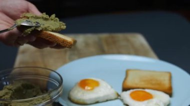 Avokado ezmesini bir dilim tostun üzerine serpiştiriyorum..