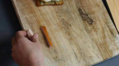 Aşçı, kızarmış yumurtalarla birlikte sosis dilimlerinden ahşap bir tahtanın üzerinde Mart kelimesini oluşturuyor. 8 Mart için temalı kahvaltı hazırlıyorum..