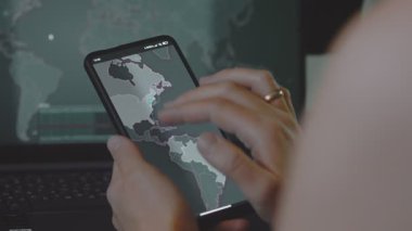 Cep telefonu ekranında dünya haritasıyla küresel siber saldırı. İnternet ağı iletişimi siber saldırı altında. Dünya çapında virüs yayılımı çevrimiçi. Yakın çekim.