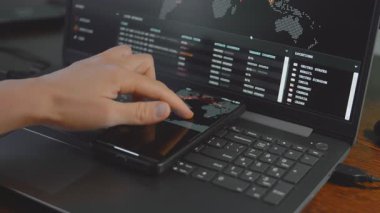 Cep telefonu ve bilgisayar ekranında dünya haritası olan küresel siber saldırı. İnternet ağı iletişimi siber saldırı altında. Dünya çapında virüs yayılımı çevrimiçi. Yakın çekim.