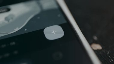 Kişi, finansal uygulama arayüzü içinde yeni veri eklemek için artı dijital düğmeye tıklar.