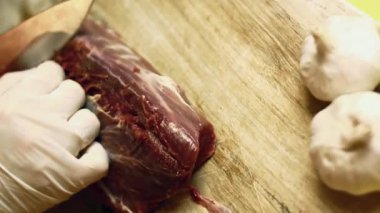 Keskin bir bıçakla gümüş deriyi sığır filetosundan ayırmaya yakın durun..