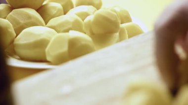 Çiğ organik sarı patates parçalarıyla ilgilenen kişi..