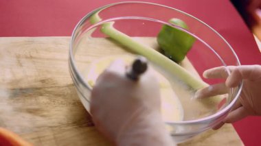 Kişi çiğ yumurtaları sütle karıştırmak için çırpıcı kullanıyor..