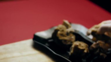 Bir parça haşlanmış et, tahta bir yüzeyde bıçakla dilimlenir..